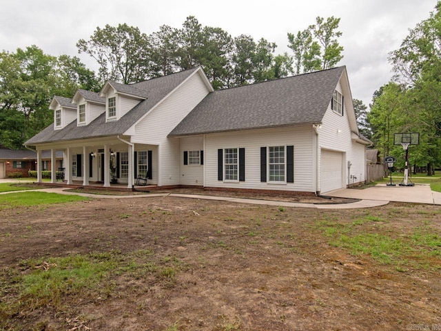 cape cod home with covered porch and a garage