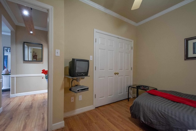 bedroom featuring light hardwood / wood-style floors, ceiling fan, and crown molding