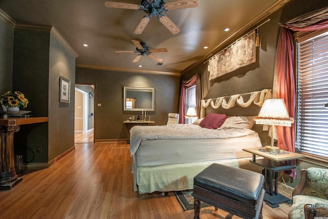 bedroom featuring hardwood / wood-style flooring, crown molding, and multiple windows