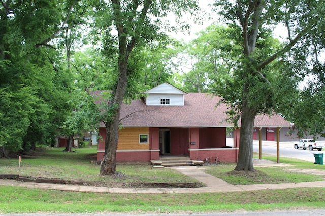 bungalow-style home with a shingled roof, brick siding, and a front yard