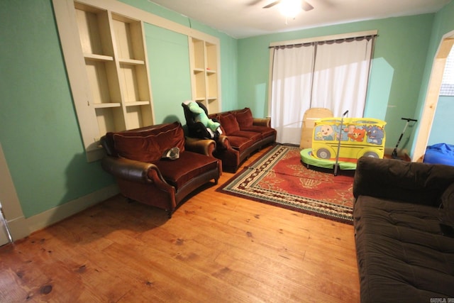 living room featuring wood finished floors, healthy amount of natural light, and built in shelves