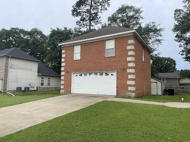 view of front facade featuring central AC unit, a front yard, and a garage