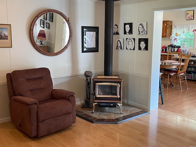 sitting room featuring hardwood / wood-style flooring and a wood stove