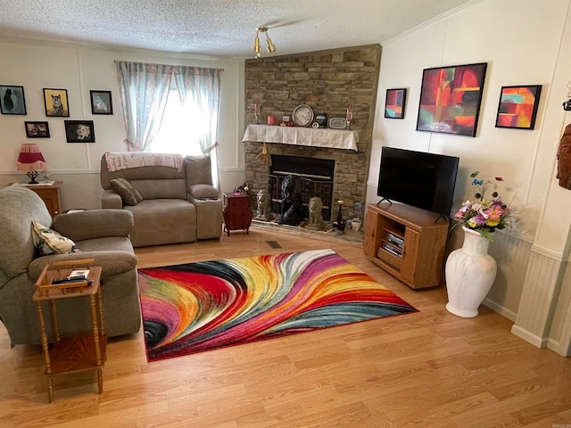 living room featuring a textured ceiling, hardwood / wood-style flooring, a fireplace, and lofted ceiling