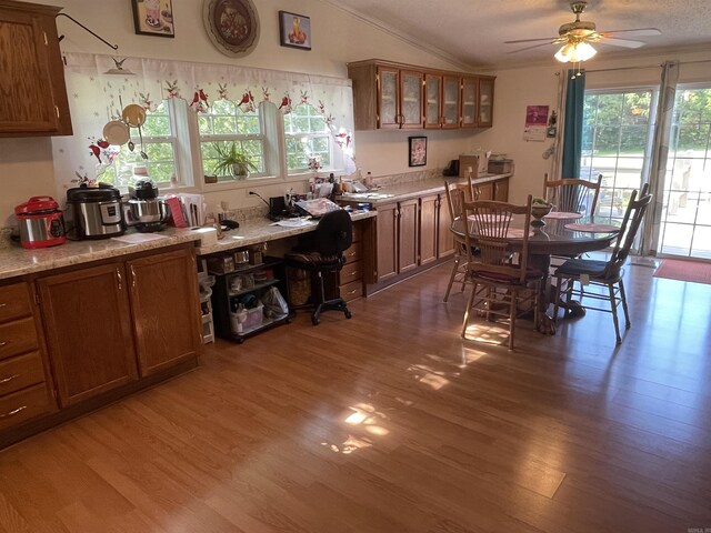 dining area with hardwood / wood-style floors, lofted ceiling, ceiling fan, and crown molding