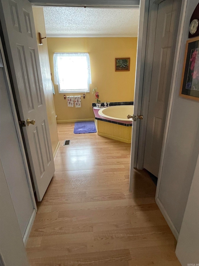 hall with a textured ceiling and hardwood / wood-style floors