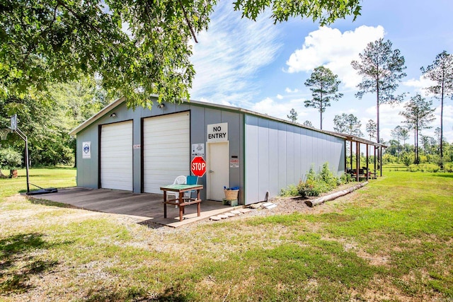 view of outdoor structure with a garage and a lawn