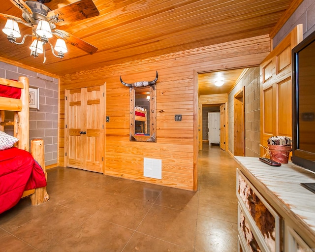 bedroom with tile patterned flooring, ceiling fan, wood walls, and wood ceiling