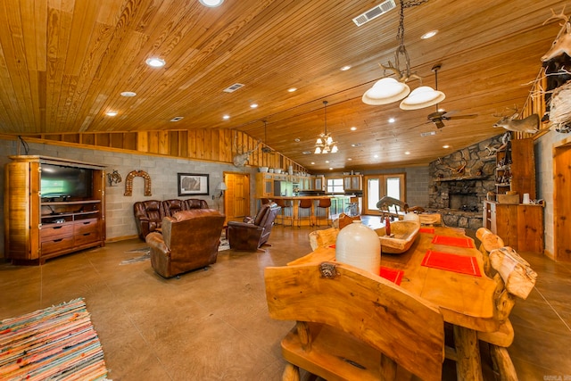 living room featuring ceiling fan with notable chandelier, high vaulted ceiling, a stone fireplace, and wooden ceiling