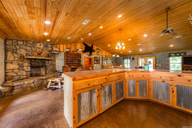 kitchen with kitchen peninsula, vaulted ceiling, wooden walls, a fireplace, and wood ceiling