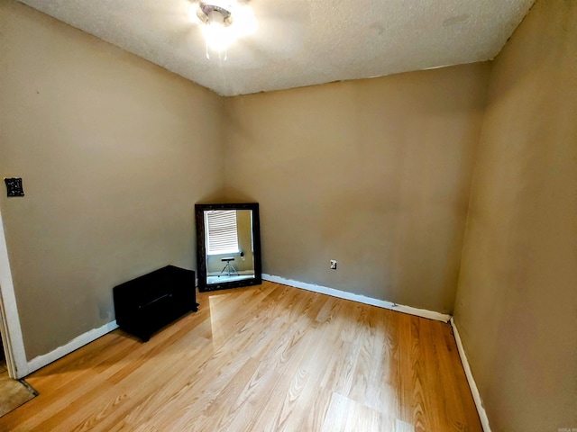 unfurnished room with hardwood / wood-style floors and a textured ceiling