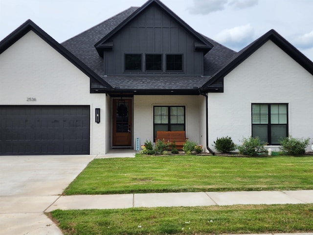 view of front of property with a porch, a garage, and a front lawn