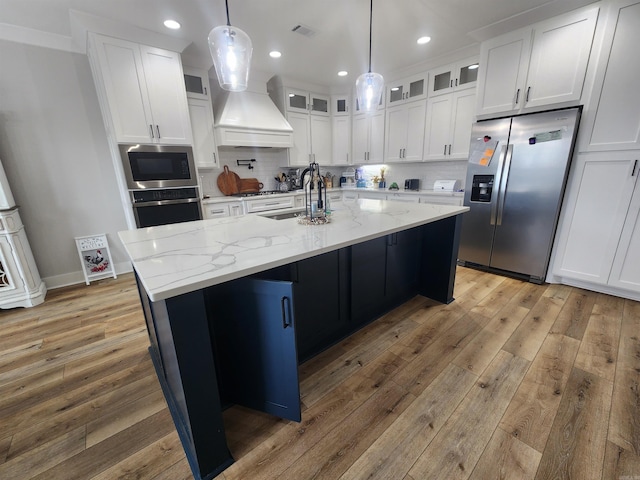 kitchen with white cabinetry, a center island with sink, stainless steel appliances, and sink