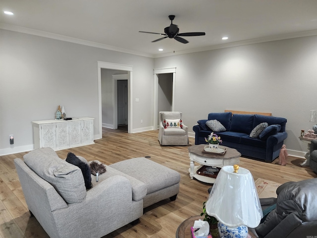 living room with ceiling fan, ornamental molding, and light wood-type flooring