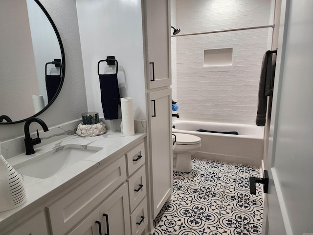 full bathroom with tile patterned floors, vanity, tiled shower / bath combo, and toilet