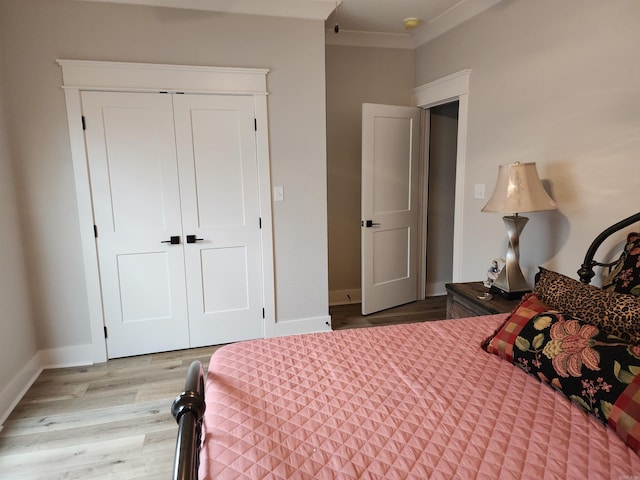 bedroom with a closet, light wood-type flooring, and ornamental molding