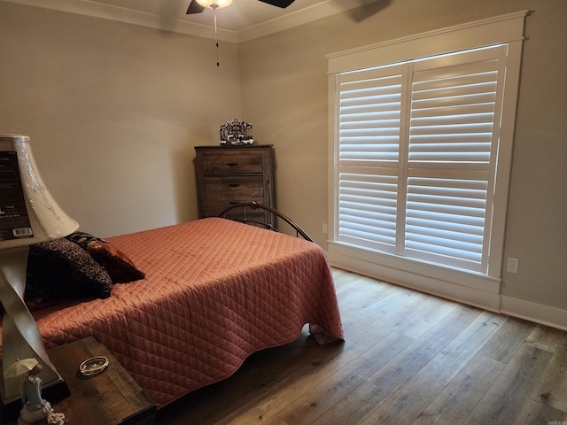 bedroom featuring ceiling fan, crown molding, and light hardwood / wood-style floors