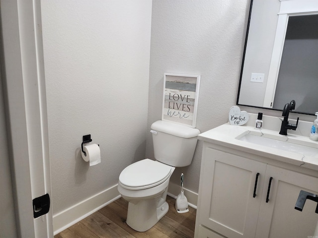 bathroom featuring vanity, hardwood / wood-style flooring, and toilet