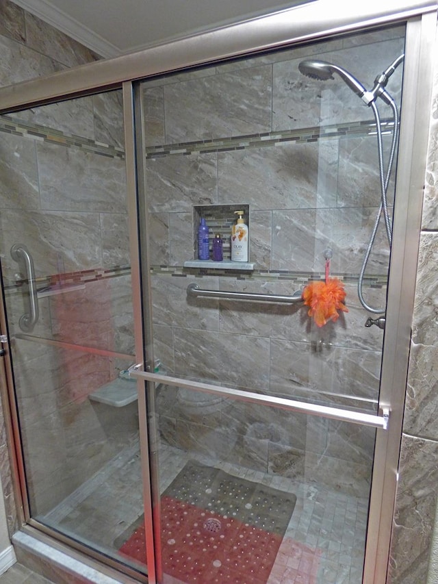 bathroom with an enclosed shower and ornamental molding