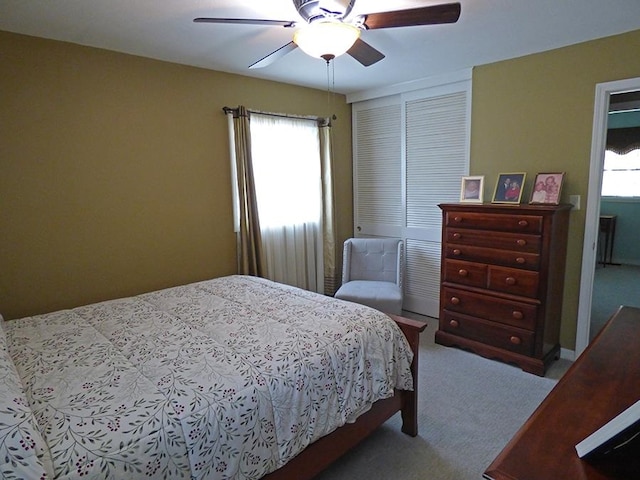 carpeted bedroom with multiple windows and ceiling fan