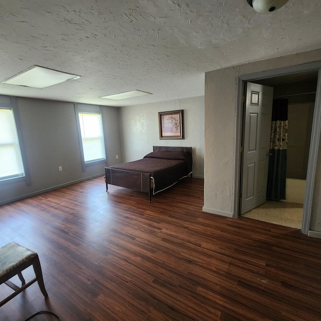 unfurnished bedroom with a textured ceiling and wood-type flooring