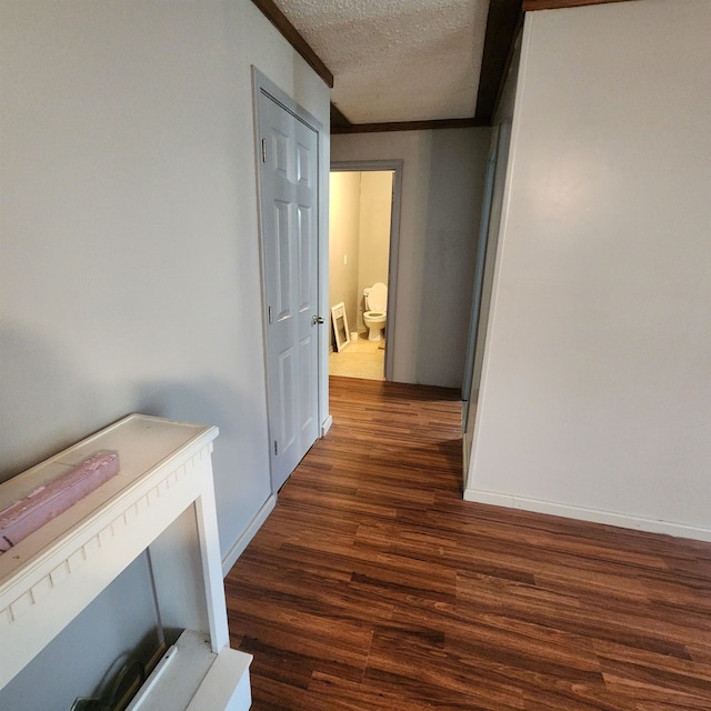 hall featuring a textured ceiling and dark hardwood / wood-style flooring