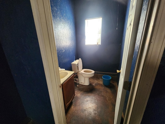 bathroom featuring concrete floors, vanity, and toilet