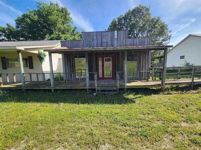 back of house featuring a lawn and a wooden deck