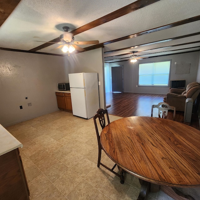 tiled dining room featuring ceiling fan and a textured ceiling