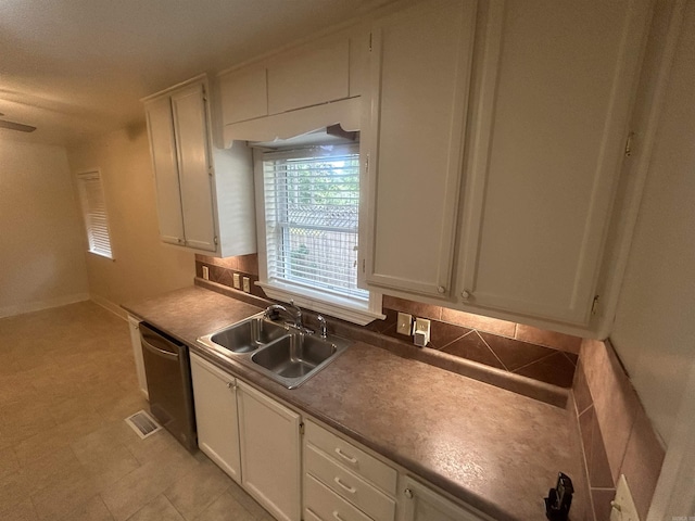 kitchen featuring a sink, decorative backsplash, dishwasher, and white cabinets