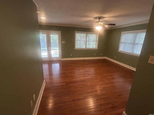 empty room with baseboards, ceiling fan, dark wood-style flooring, and crown molding