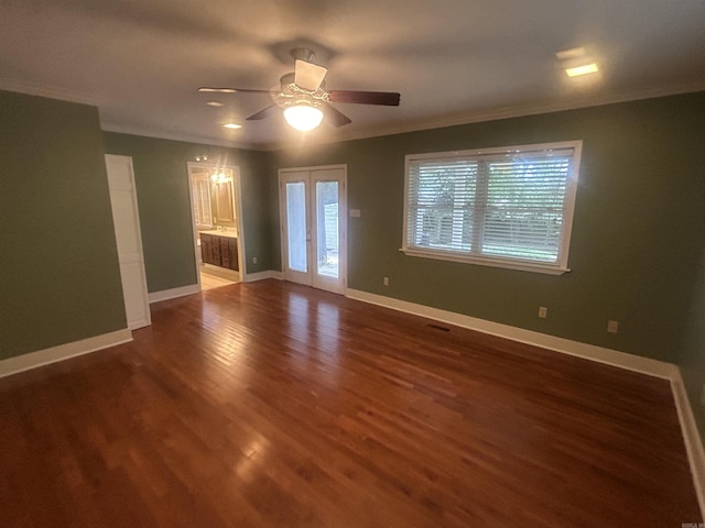 empty room featuring dark wood-style floors, french doors, crown molding, baseboards, and ceiling fan