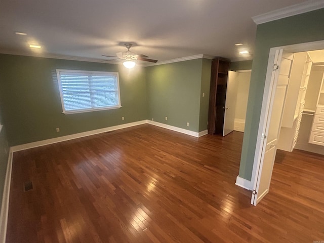 unfurnished room with dark wood finished floors, crown molding, baseboards, and ceiling fan