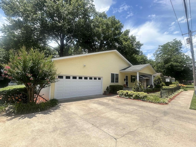 view of front of house with a garage, driveway, and fence