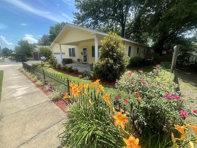 view of front of house featuring a fenced front yard, a garage, and concrete driveway