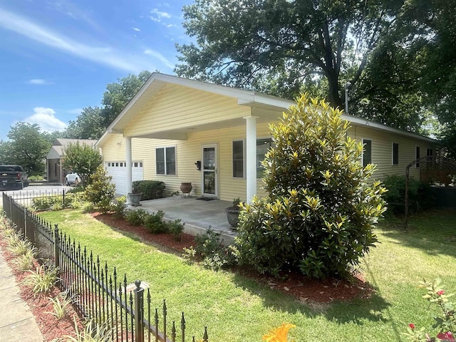 view of front of home featuring a front yard, fence, and a garage