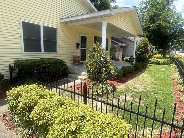 property entrance featuring a lawn