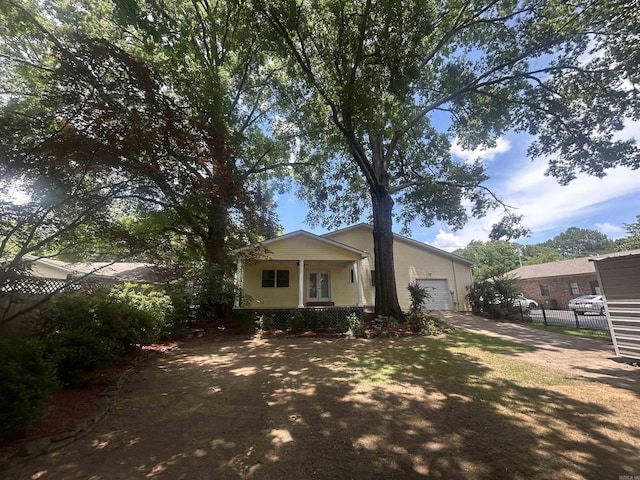 view of front of home with concrete driveway, an attached garage, fence, and covered porch