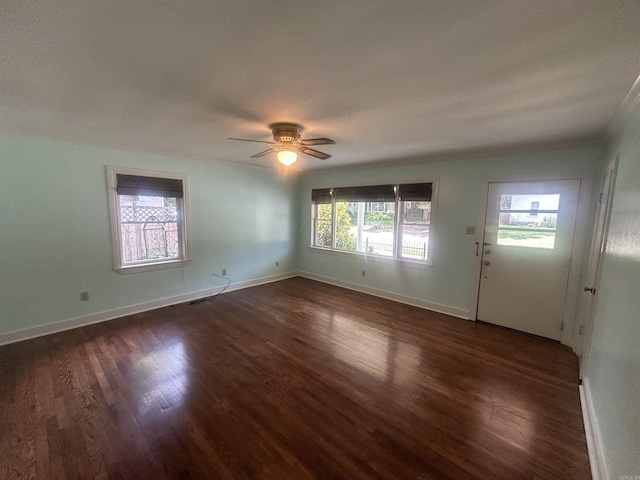 interior space featuring a ceiling fan, baseboards, and dark wood-style flooring