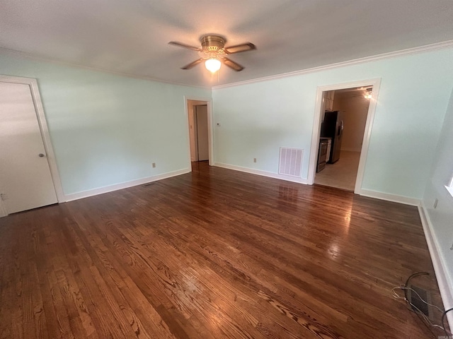 unfurnished room with visible vents, baseboards, ornamental molding, and dark wood-style flooring