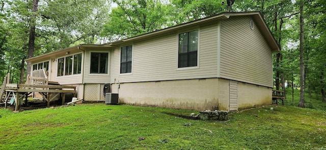 rear view of house with a lawn, central AC unit, and a deck