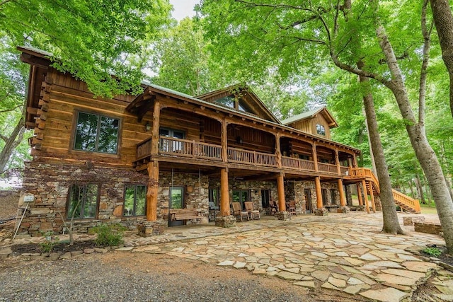 rear view of property featuring a balcony and a patio