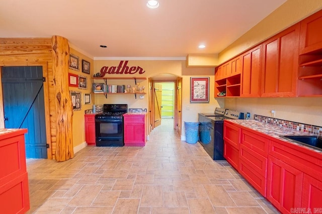 kitchen with crown molding, sink, independent washer and dryer, and black gas range oven