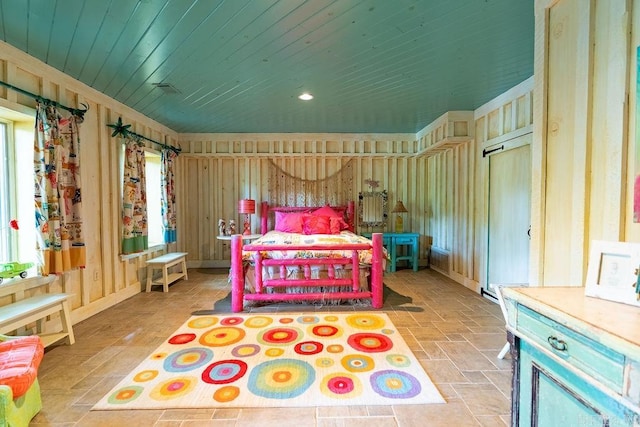 bedroom featuring wood walls and multiple windows