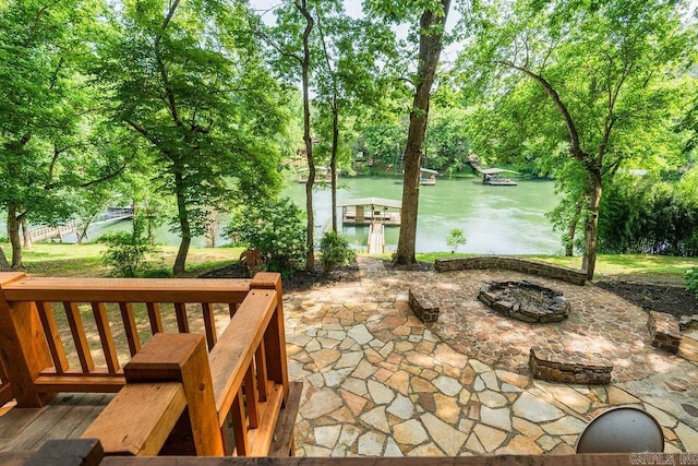 exterior space with a dock, a water view, and a fire pit