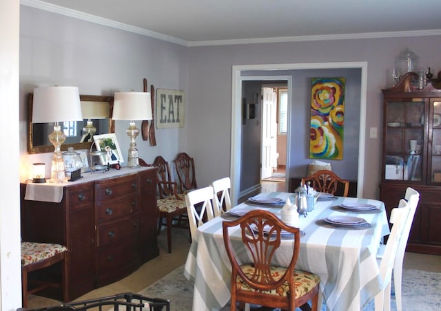 carpeted dining space with crown molding