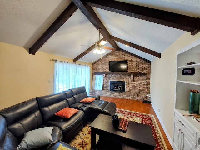 living area with a textured ceiling, vaulted ceiling with beams, light wood-style flooring, and a ceiling fan