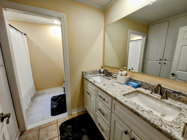 full bath with baseboards, double vanity, ornamental molding, and a sink