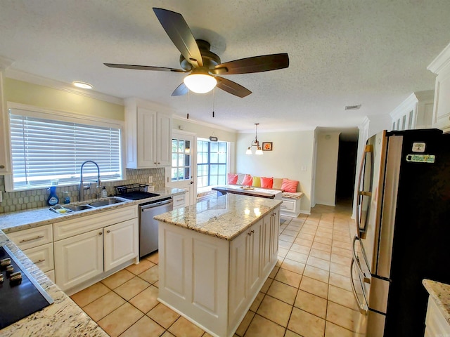 kitchen with crown molding, stainless steel appliances, a sink, light tile patterned flooring, and ceiling fan