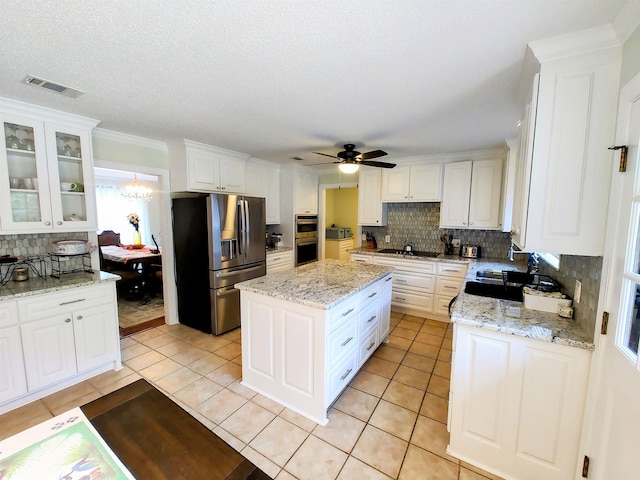 kitchen featuring white cabinetry, visible vents, stainless steel appliances, and ceiling fan with notable chandelier